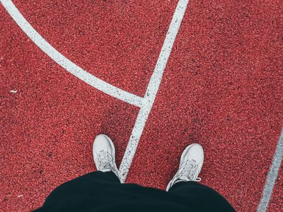 Focus on athletic shoes standing on a dark textured surface.